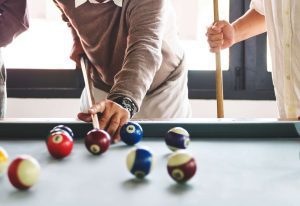 A group of friends playing billiards